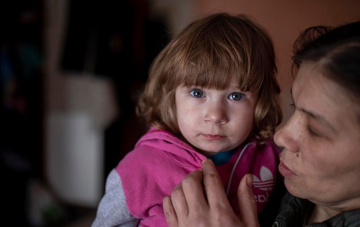 A child is held by their mother in eastern Ukraine.