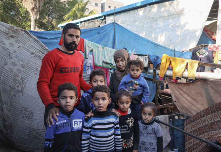 In a shelter for internally displaced persons in Rafah, Mahmoud and his wife Eman pose for a photograph with their children. Image credits © UNICEF/El Baba